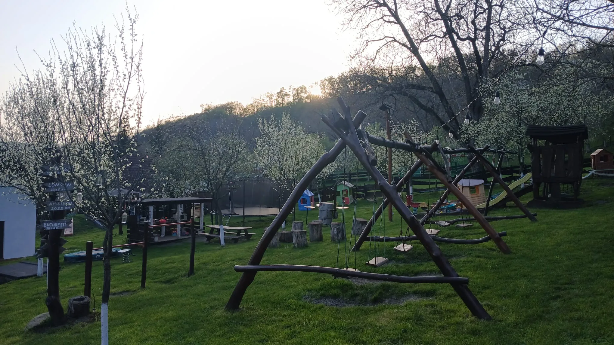 Playground with swings and a trampoline at sunset
