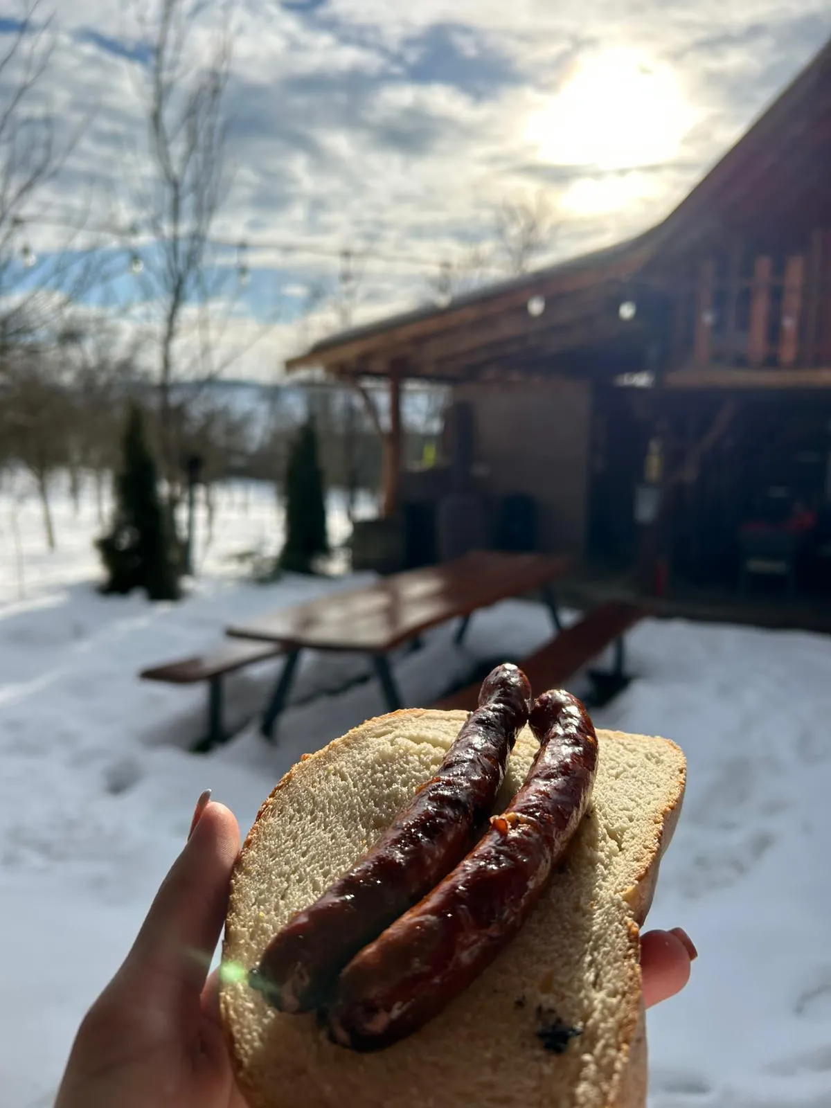 Grilled sausages on bread in a snowy setting