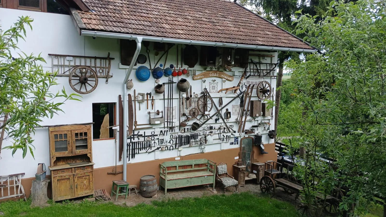 Vintage farm tools displayed on the house wall