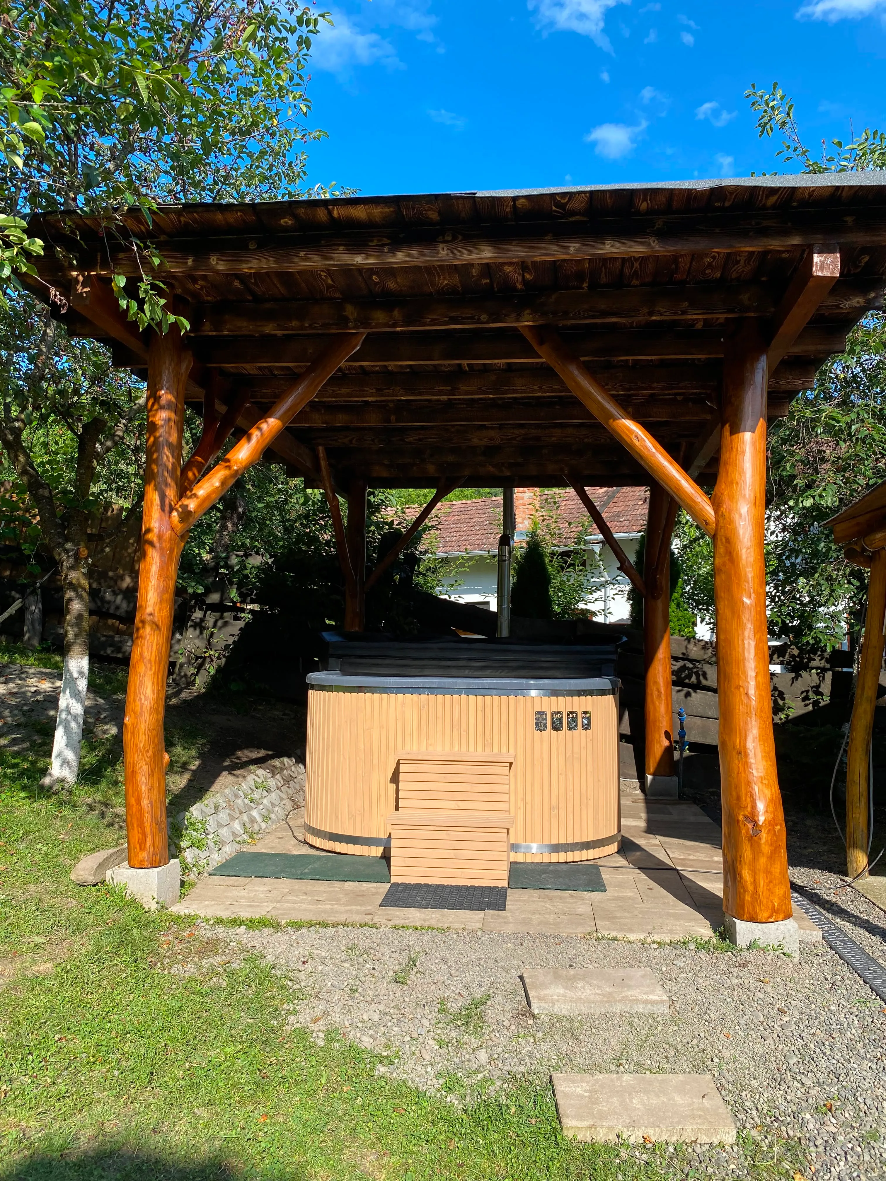 Wood-fired hot tub under its own timber shelter